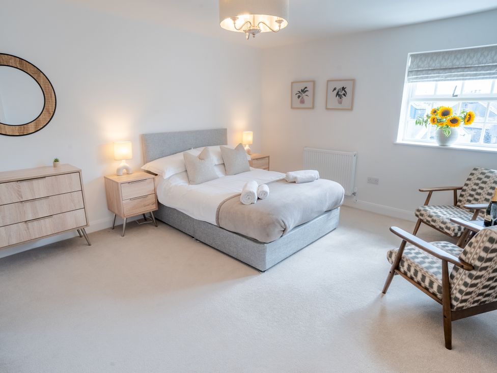 A bedroom with a bed and two chairs at Ullswater in Ulverston