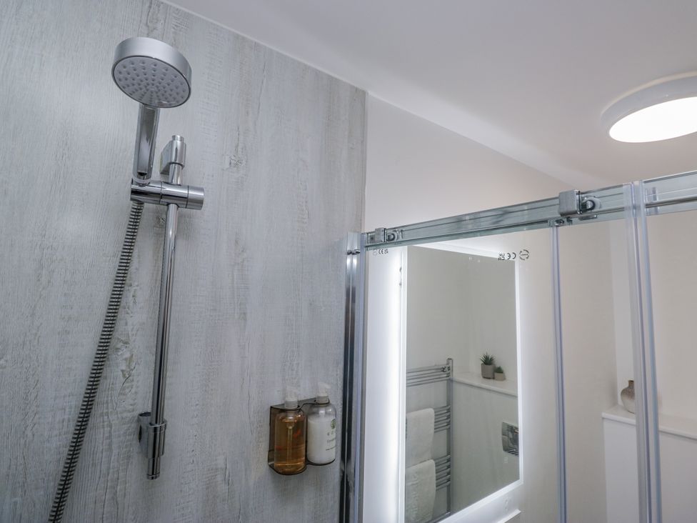 A bathroom with a shower and mirror cabinet at Ullswater in Ulverston