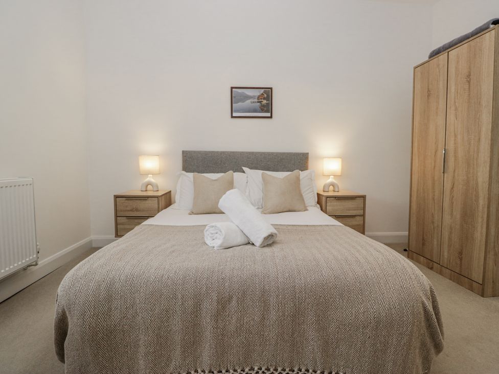 A bedroom with a bed and nightstands at Ullswater in Ulverston