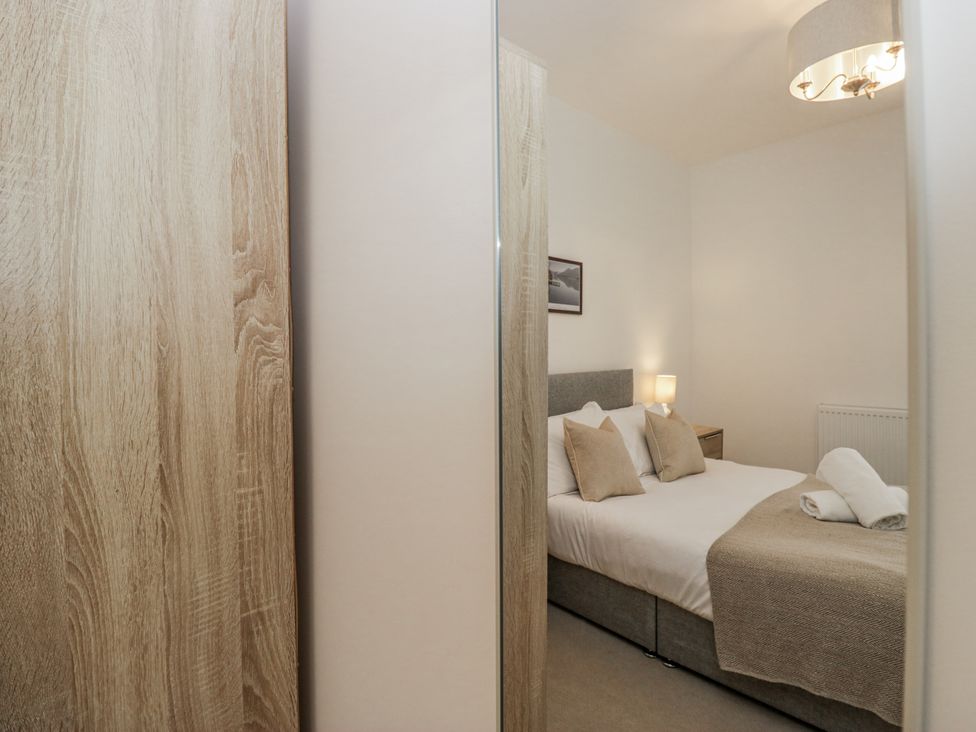 A bedroom with a bed and nightstand at Ullswater in Ulverston