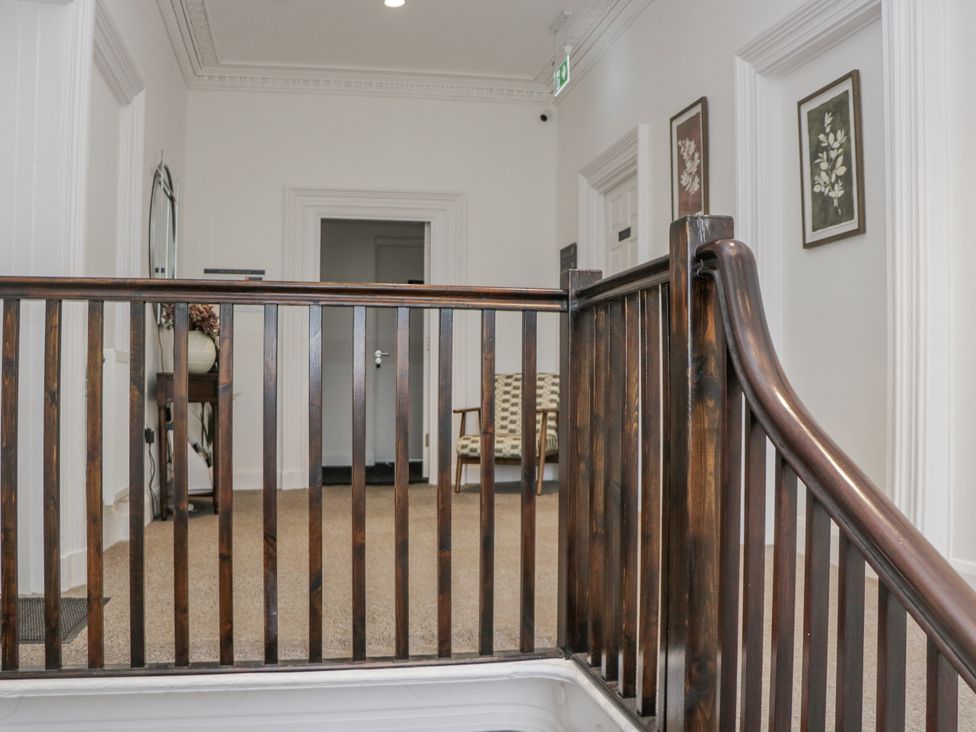 A hallway with a staircase and a chair at Ullswater in Ulverston