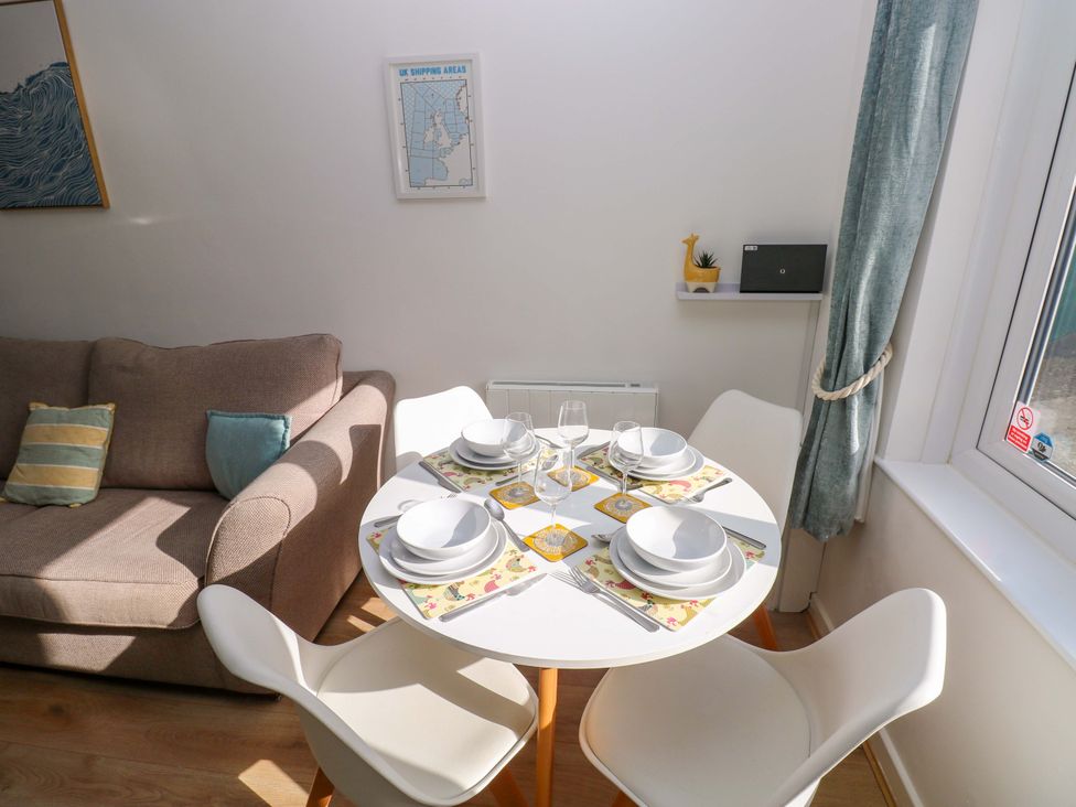 A dining area with a table set for four at No.22 The Clicketts Tenby