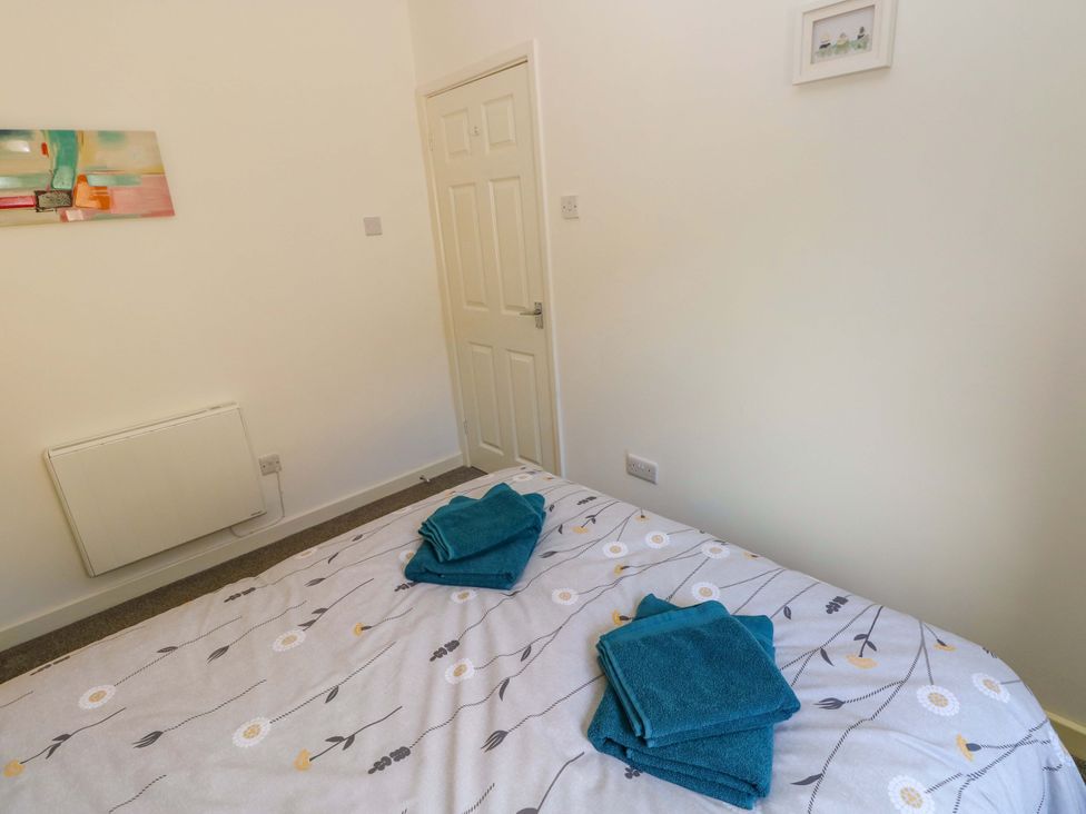 A bedroom with towels on a bed at No.22 The Clicketts in Tenby