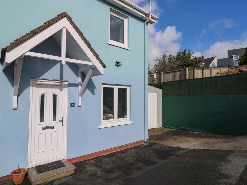 An exterior view of a house with a blue wall and a front door at No.22 The Clicketts in Tenby