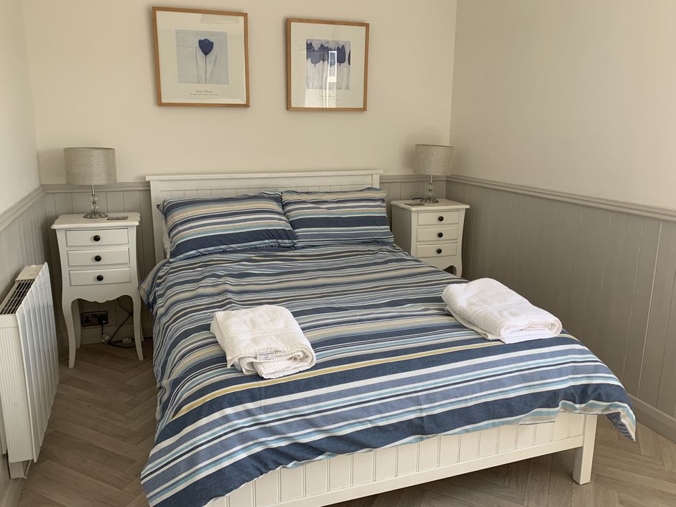 A bedroom with a bed and bedside tables at Lavender Cottage Beadnell
