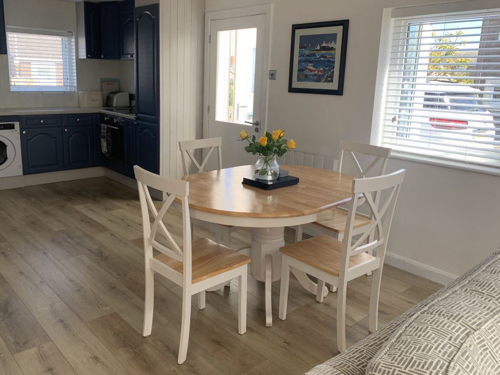 A dining room with a table and chairs at Lavender Cottage Beadnell