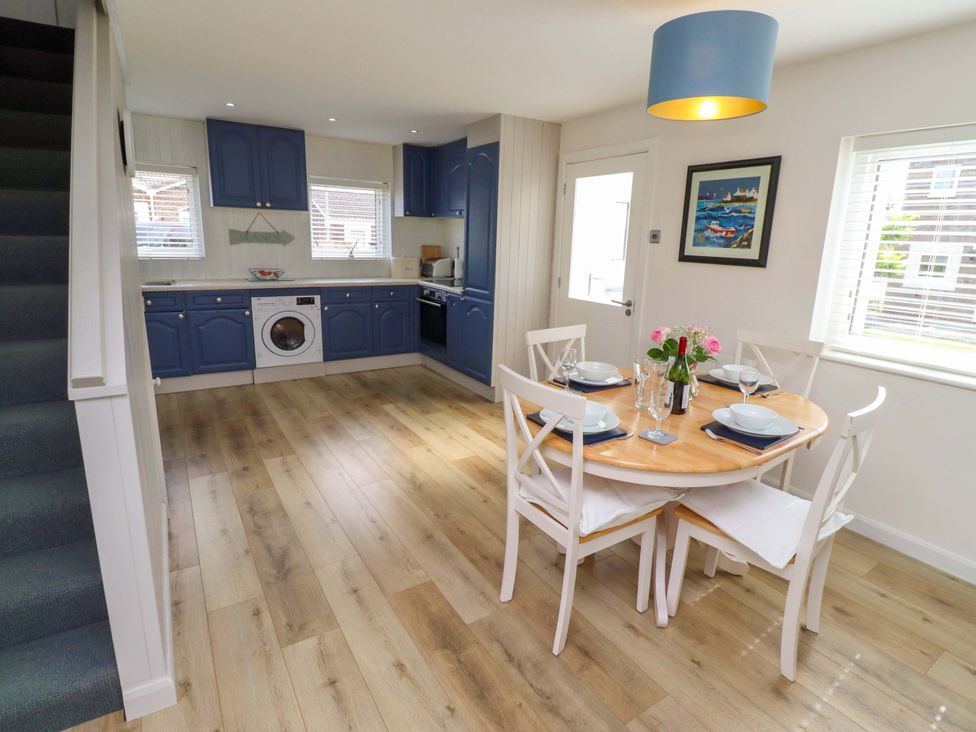 A dining room with a round table and chairs at Lavender Cottage in Beadnell