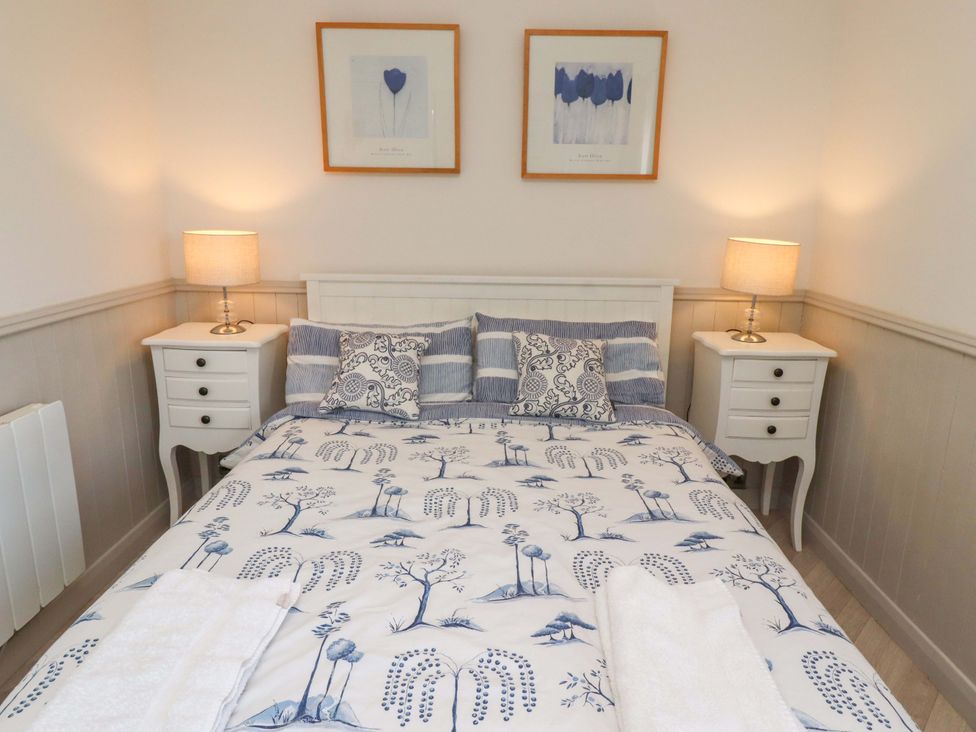A bedroom with a bed and furniture at Lavender Cottage Beadnell