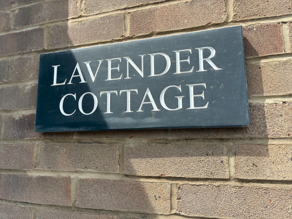 A sign reading Lavender Cottage on a brick wall at Lavender Cottage in Beadnell
