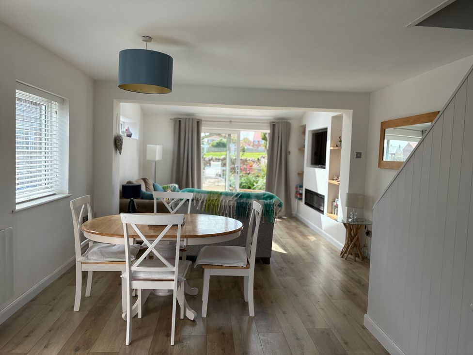 A dining area with a round table and chairs at Lavender Cottage Beadnell