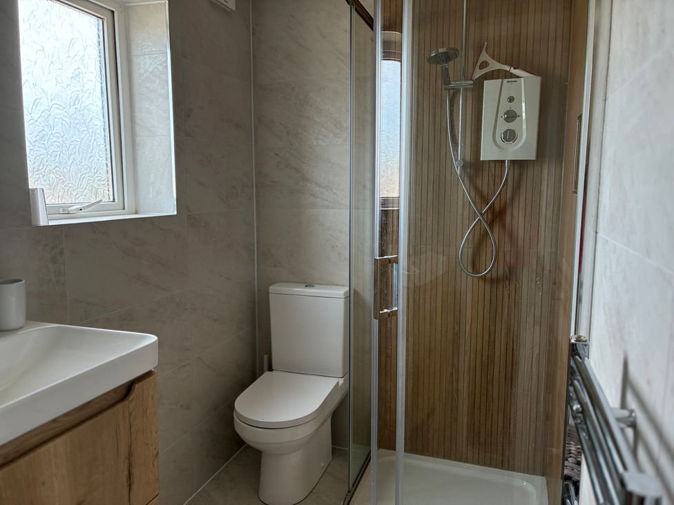 A bathroom with a shower and toilet at Lavender Cottage in Beadnell