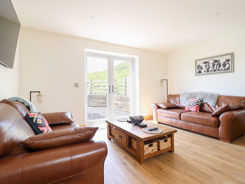 A living room with sofas and a coffee table at Bryn Bras in Corwen
