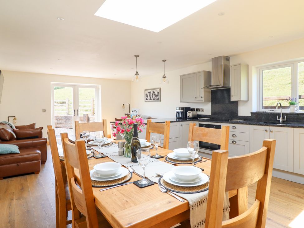 A kitchen with a dining area and kitchen appliances at Bryn Bras in Corwen
