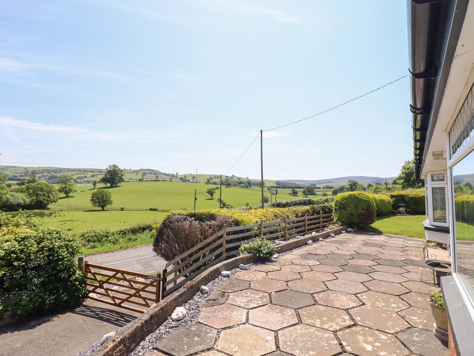 An outdoor view with a gate and greenery at Bryn Bras in Corwen