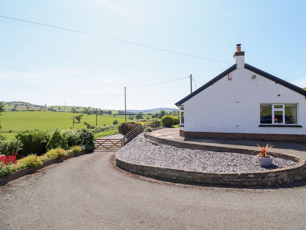 A house with a gravel area and gate at Bryn Bras in Corwen