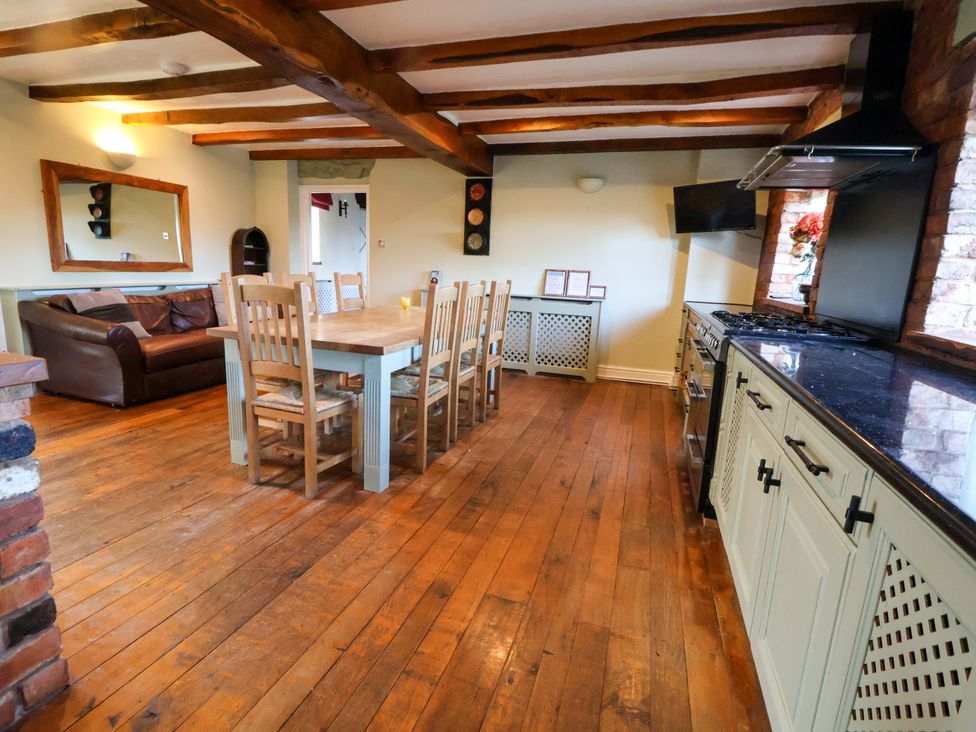 A kitchen with a dining table and chairs and a sofa at Home Farm St Asaph