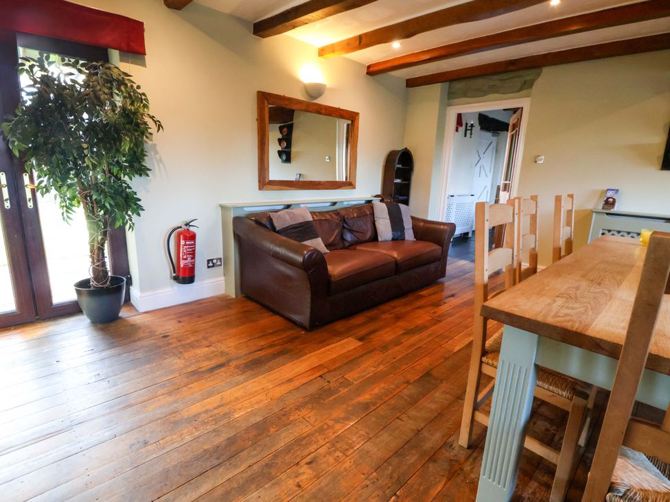 A dining room with a sofa and dining table at Home Farm St Asaph