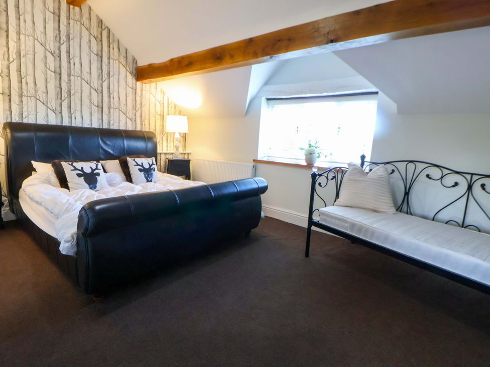 A bedroom with a bed and a sofa at Home Farm St Asaph