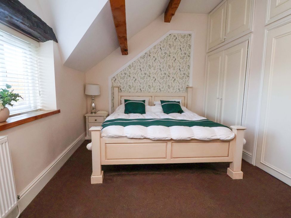 A bedroom with a bed and nightstand at Home Farm in St Asaph