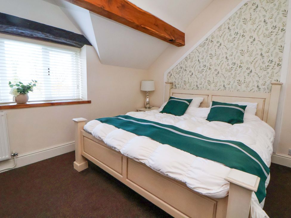 A bedroom with a bed and window at Home Farm in St Asaph