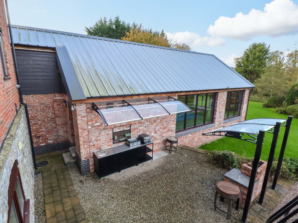 An outdoor area with a barbecue and seating at Home Farm St Asaph