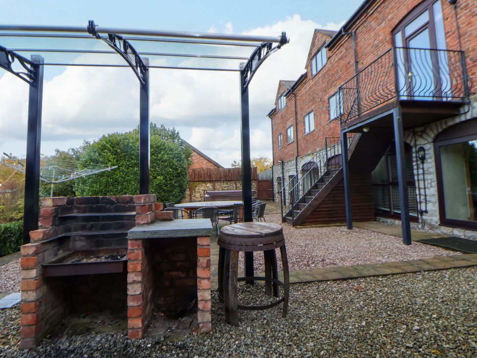 A garden with a grill and a stool at Home Farm St Asaph