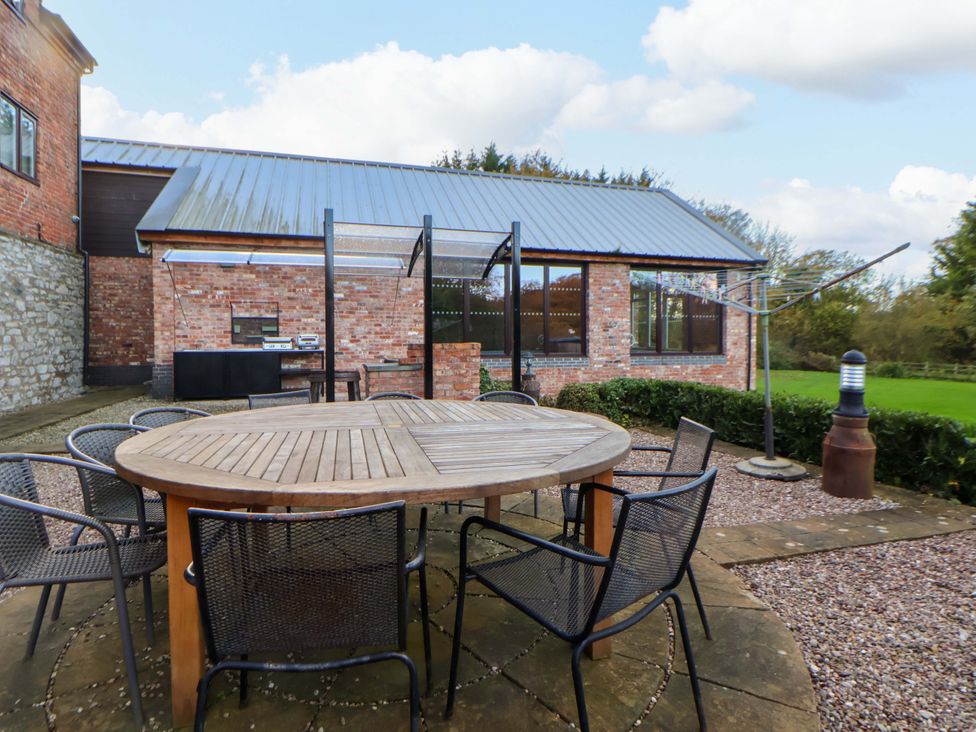 An outdoor area with a table and chairs at Home Farm in St Asaph