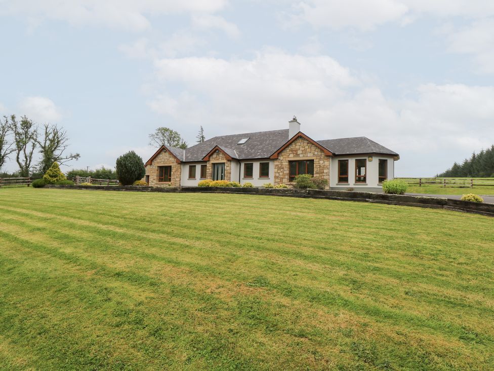 An outdoor view of a house with a lawn at Swan Lake in Cloonshaghan near Boyle, County Roscommon