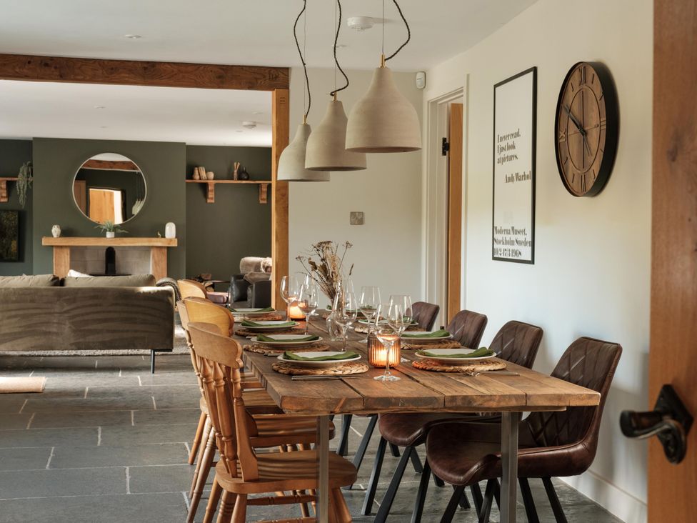 A dining room with a table set for meals at Lower Well Farm House in Totnes