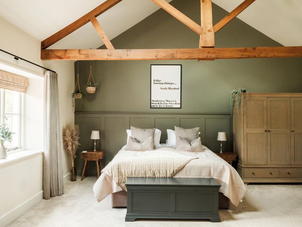 A bedroom with a bed and wardrobe at Lower Well Farm House in Totnes