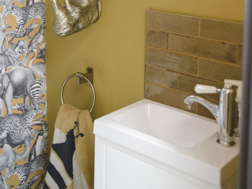 A washbasin with a faucet in a bathroom at Lower Well Farm House in Totnes