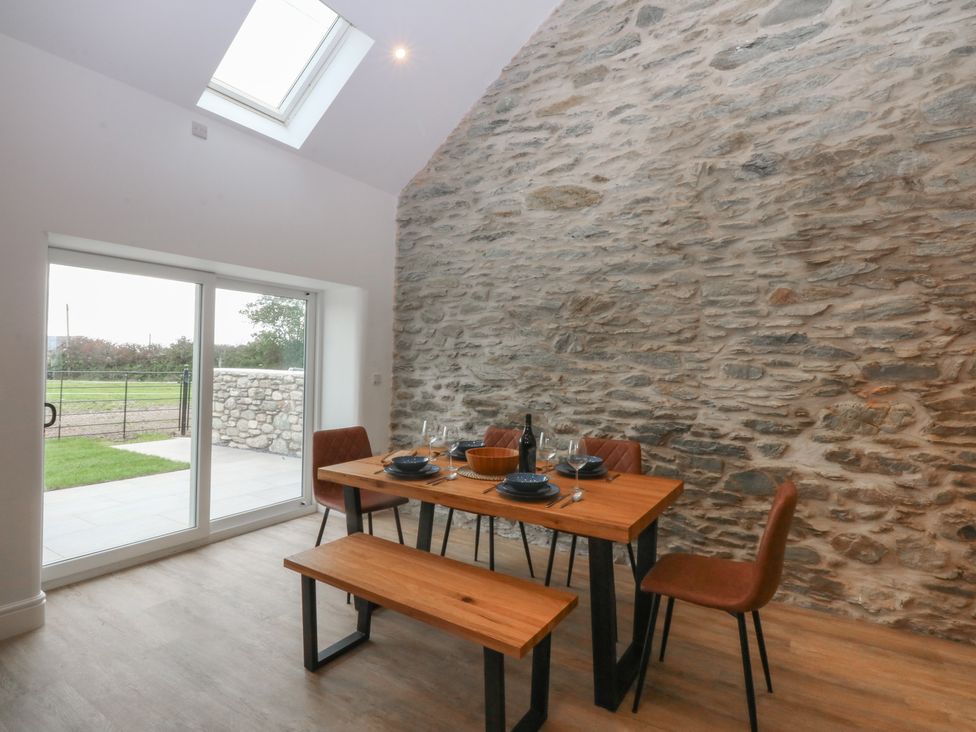 A dining room with a table set for meals at Beudy