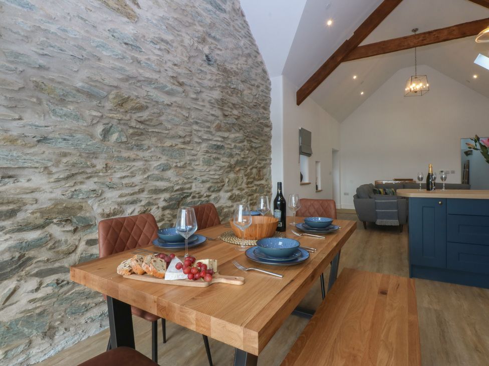 A dining room with a wooden table and chairs at Beudy