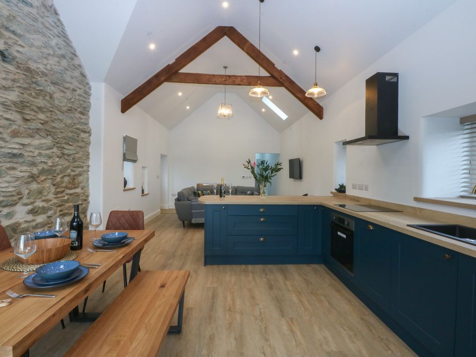 A kitchen with a dining table and sofa at Beudy