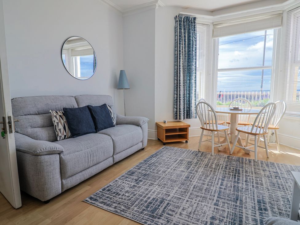 A living room with a sofa and dining table at Sea Lovers in Exmouth