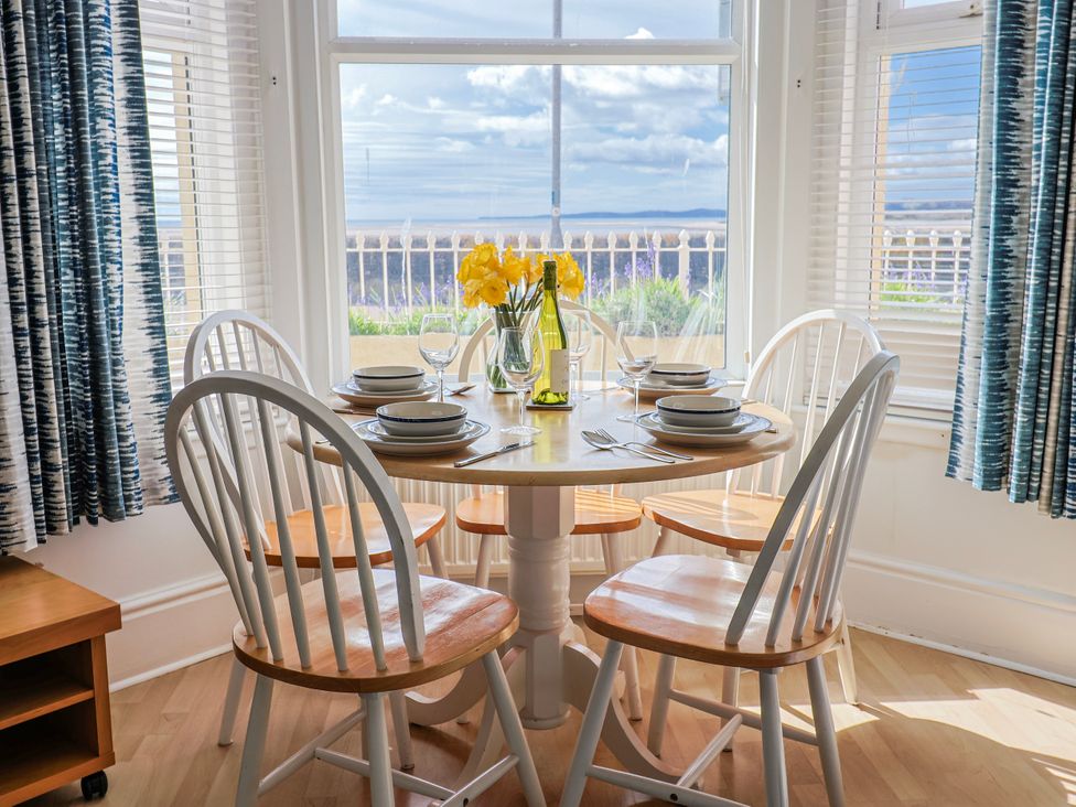 A dining room with a round table and chairs at Sea Lovers in Exmouth