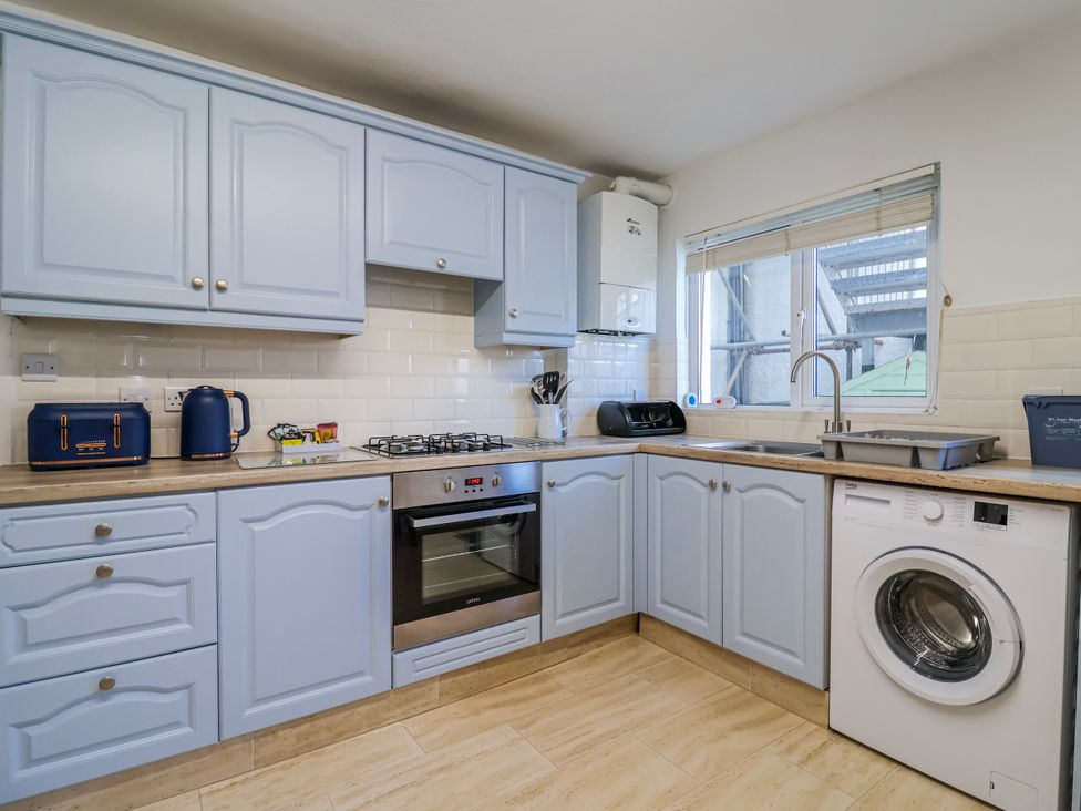A kitchen with blue cabinets and appliances at Sea Lovers in Exmouth