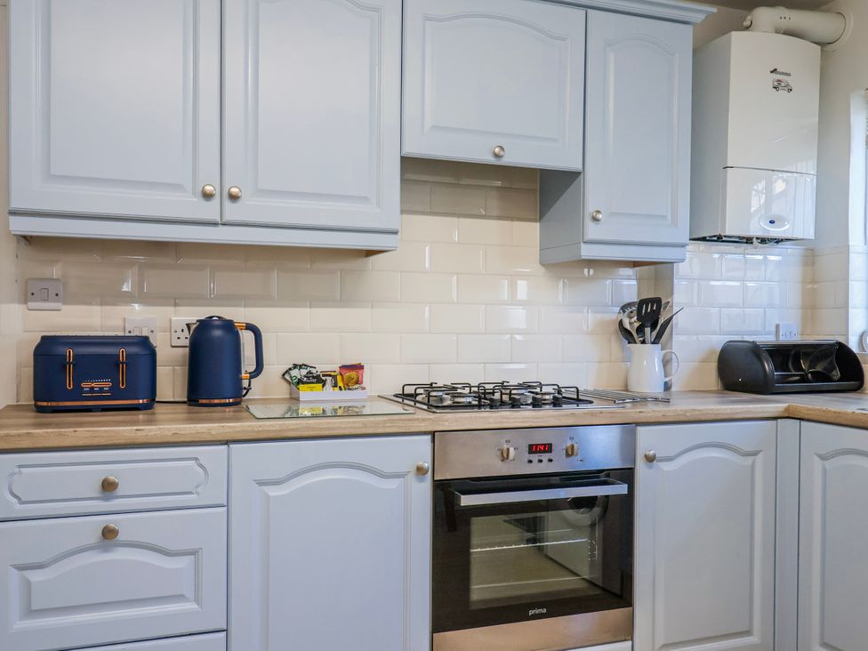 A kitchen with cabinets, a kettle, a stove, and a toaster at Sea Lovers in Exmouth