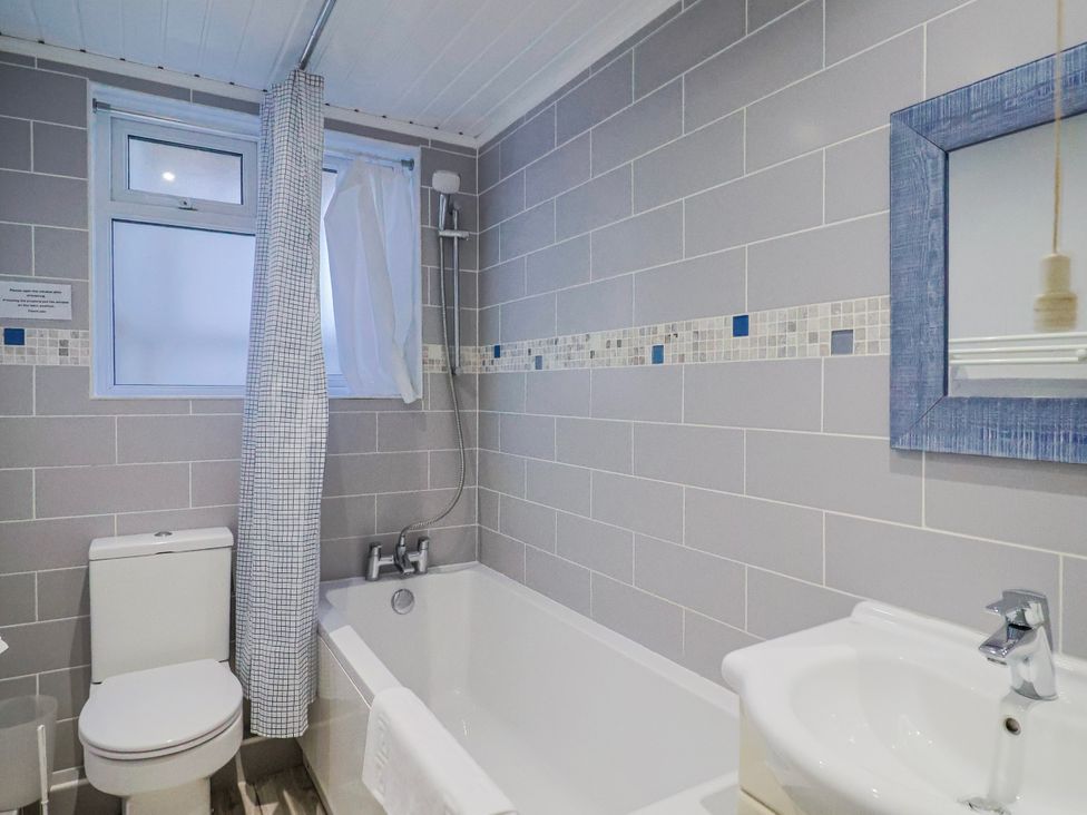 A bathroom with a bathtub, toilet, and sink at Sea Lovers in Exmouth