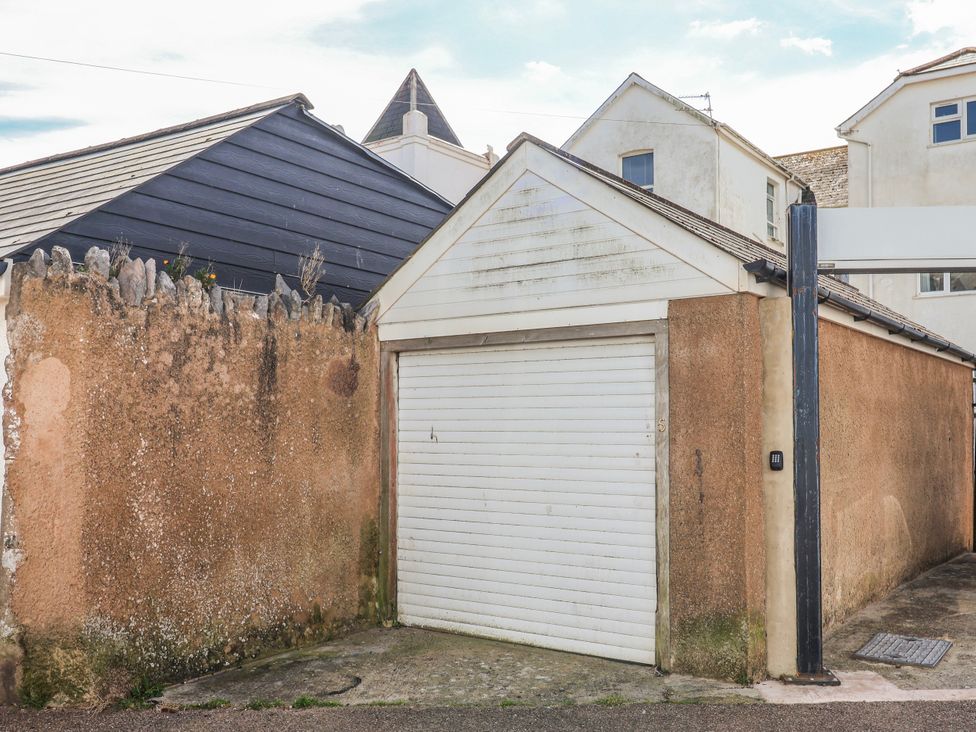 Garage with a door and surrounding wall at Sea Lovers in Exmouth