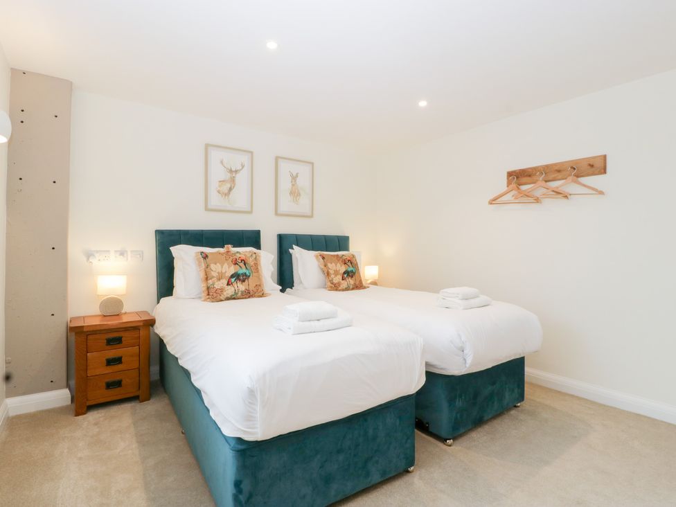 A bedroom with two beds and wall art at Hidden Well in Aust