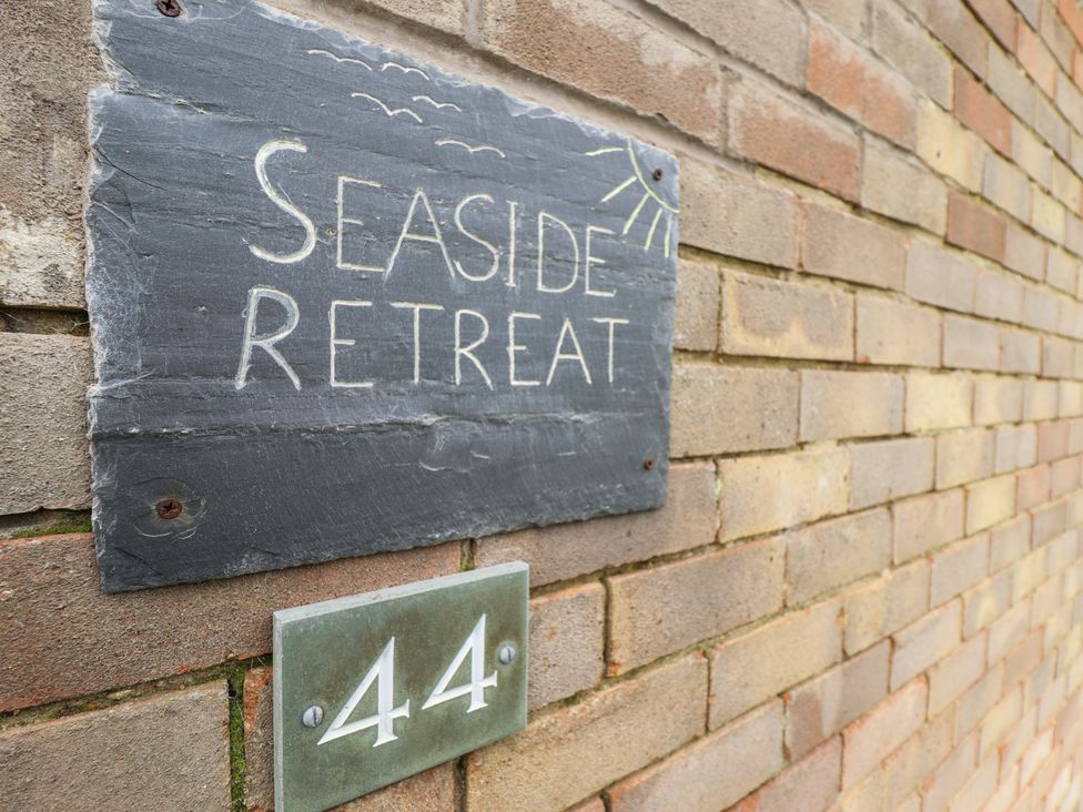 A sign displaying Seaside Retreat and number 44 at Seaside Retreat in Chapel Point near Chapel St Leonards