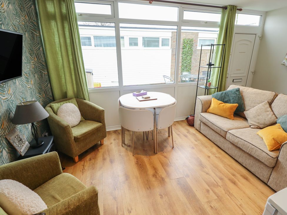 A living room with a sofa and dining table at Seaside Retreat Chapel Point near Chapel St Leonards