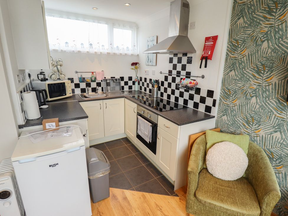 A kitchen with appliances and a seating area at Seaside Retreat Chapel Point near Chapel St Leonards