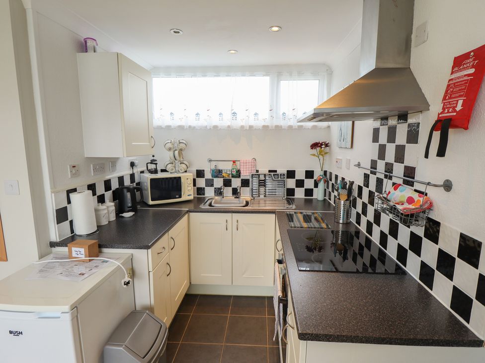 A kitchen with cabinets, sink, stove and microwave at Seaside Retreat Chapel Point near Chapel St Leonards