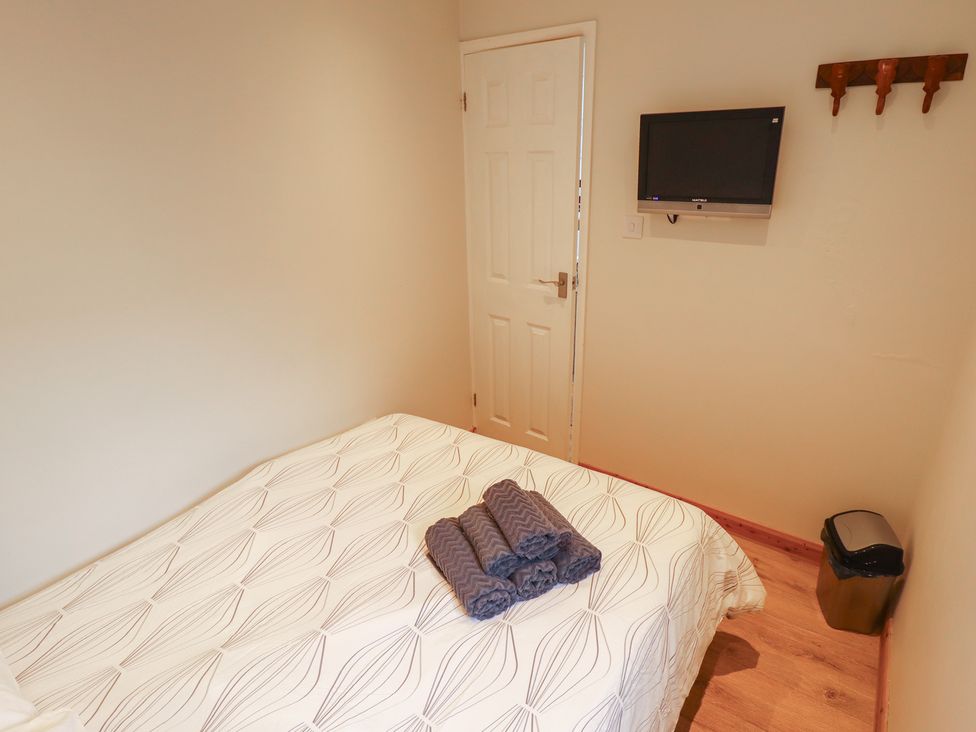 A bedroom with a bed and television at Seaside Retreat in Chapel Point near Chapel St Leonards