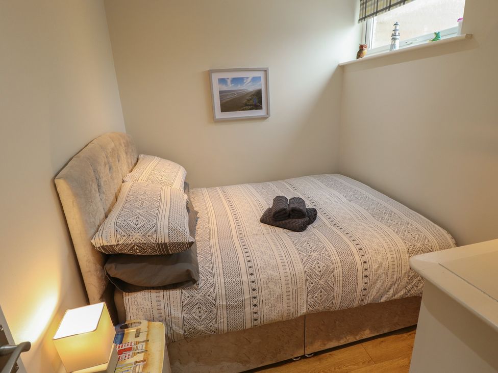 A bedroom with a bed and nightstand at Seaside Retreat in Chapel Point near Chapel St Leonards