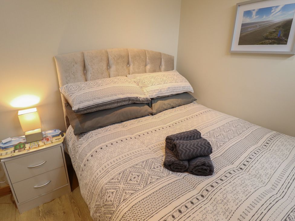 A bedroom with bed and towels arranged at Seaside Retreat Chapel Point near Chapel St Leonards