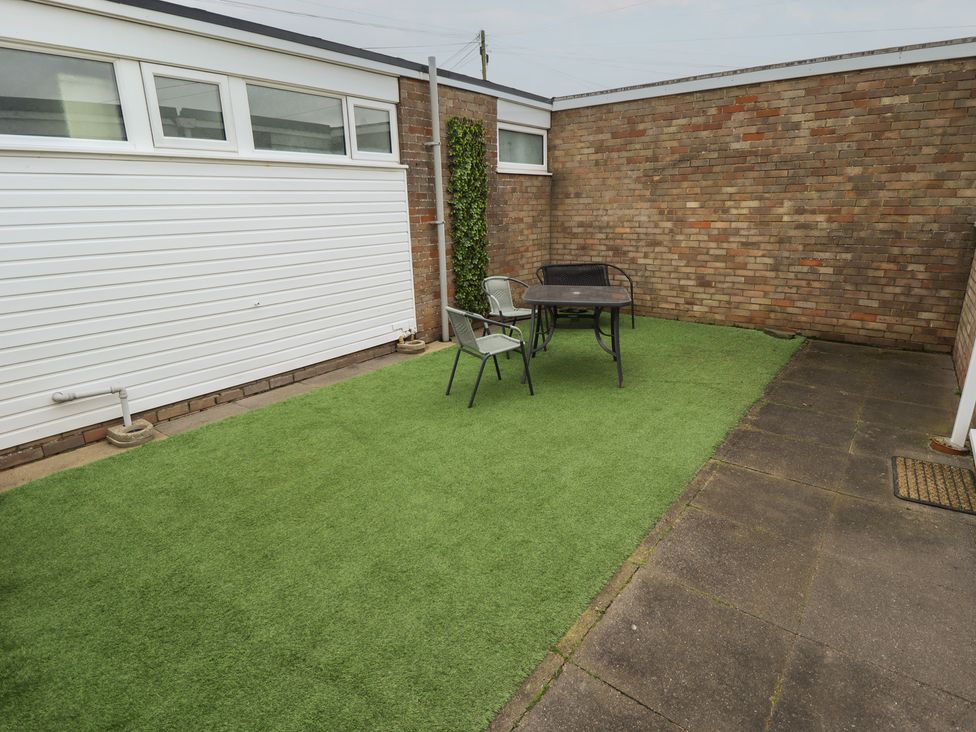 A garden with a table and chairs at Seaside Retreat in Chapel Point near Chapel St Leonards