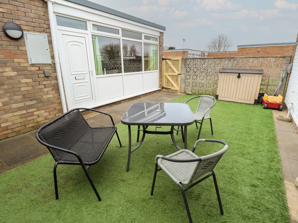 A garden with a table and chairs at Seaside Retreat Chapel Point near Chapel St Leonards
